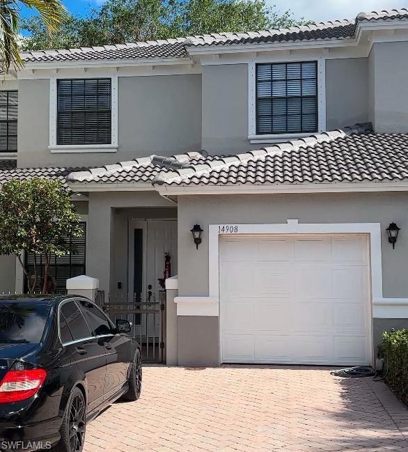 View of front of property with a tiled roof, stucc