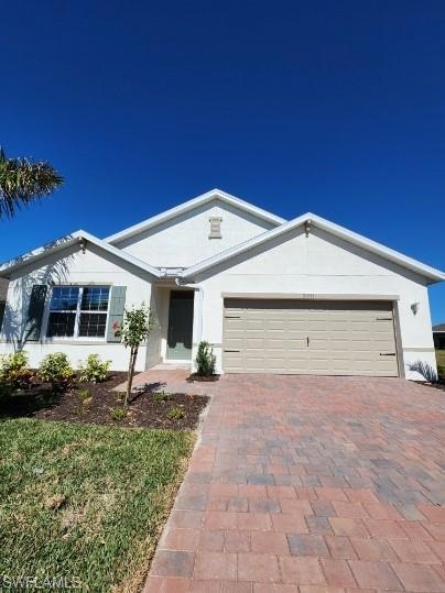 Ranch-style home with decorative driveway, an atta