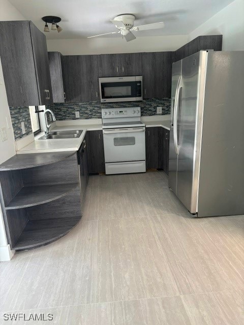Kitchen featuring tasteful backsplash, fridge, white stove, and stainless steel microwave