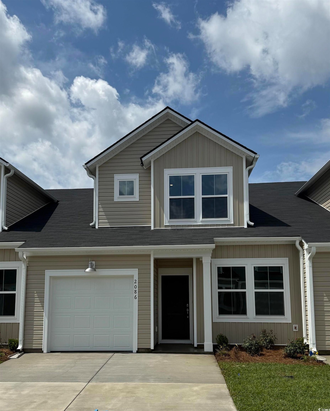 View of front facade with driveway and board and batten siding