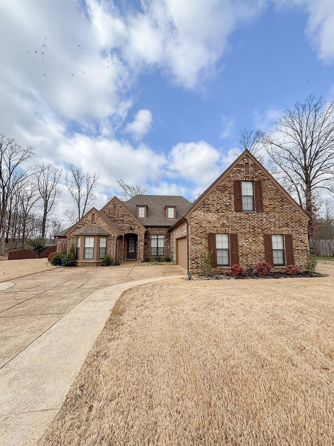 View of front of home with a garage, driveway, roo