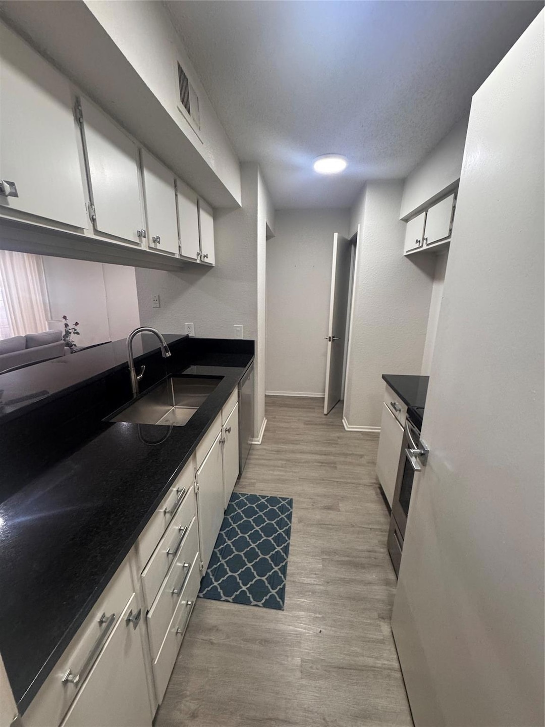 Kitchen with a sink, light wood-type flooring, ran