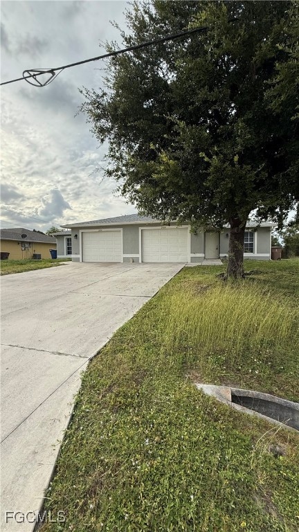 View of front of property featuring concrete driveway and an attached garage