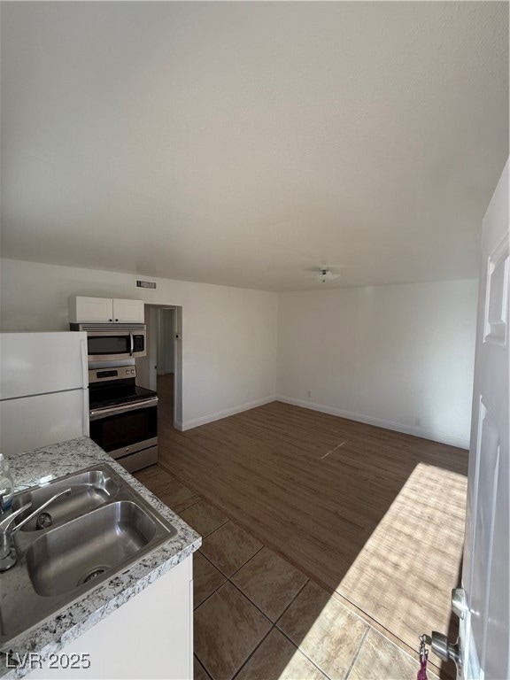 Kitchen with refrigerator, a sink, dark tile patte