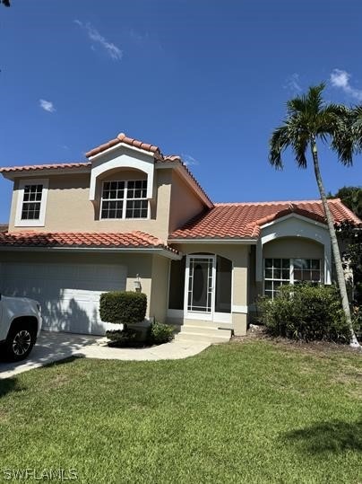 View of front of home with a front lawn and a gara