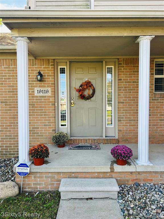 Property entrance with a porch and brick siding