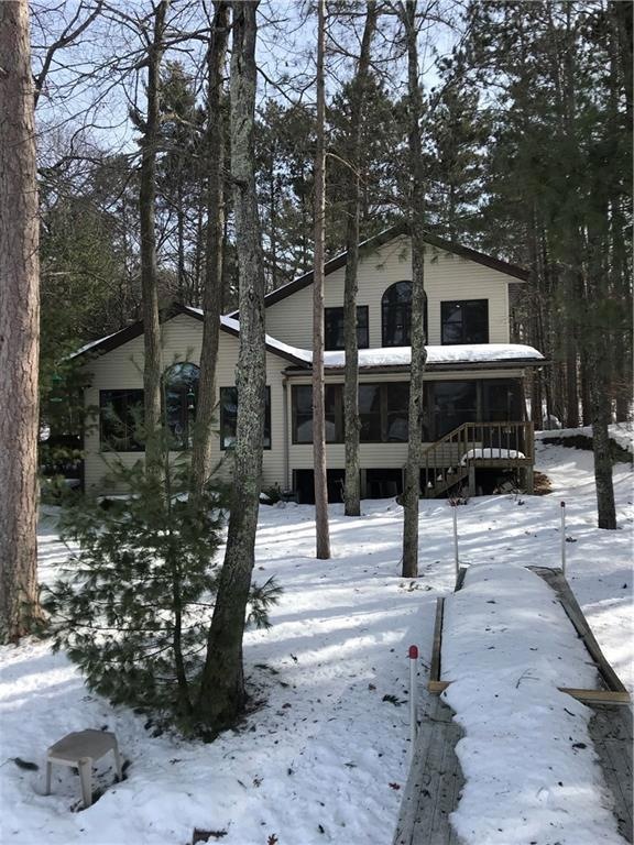 Late winter shoreline starts to melt beneath towering pines
