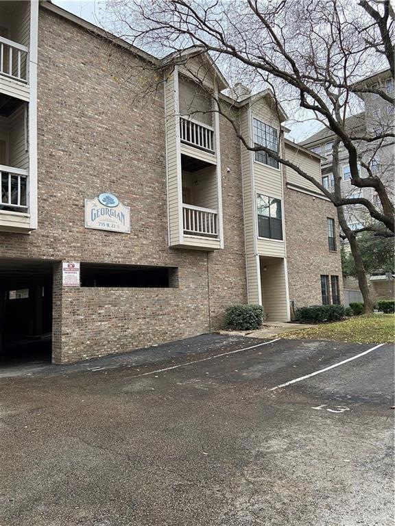 View of building exterior with uncovered parking