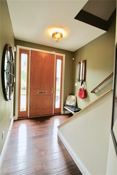Front entry hall welcomes you with wood floors and natural light from 2 sidelights on either side of the front door.