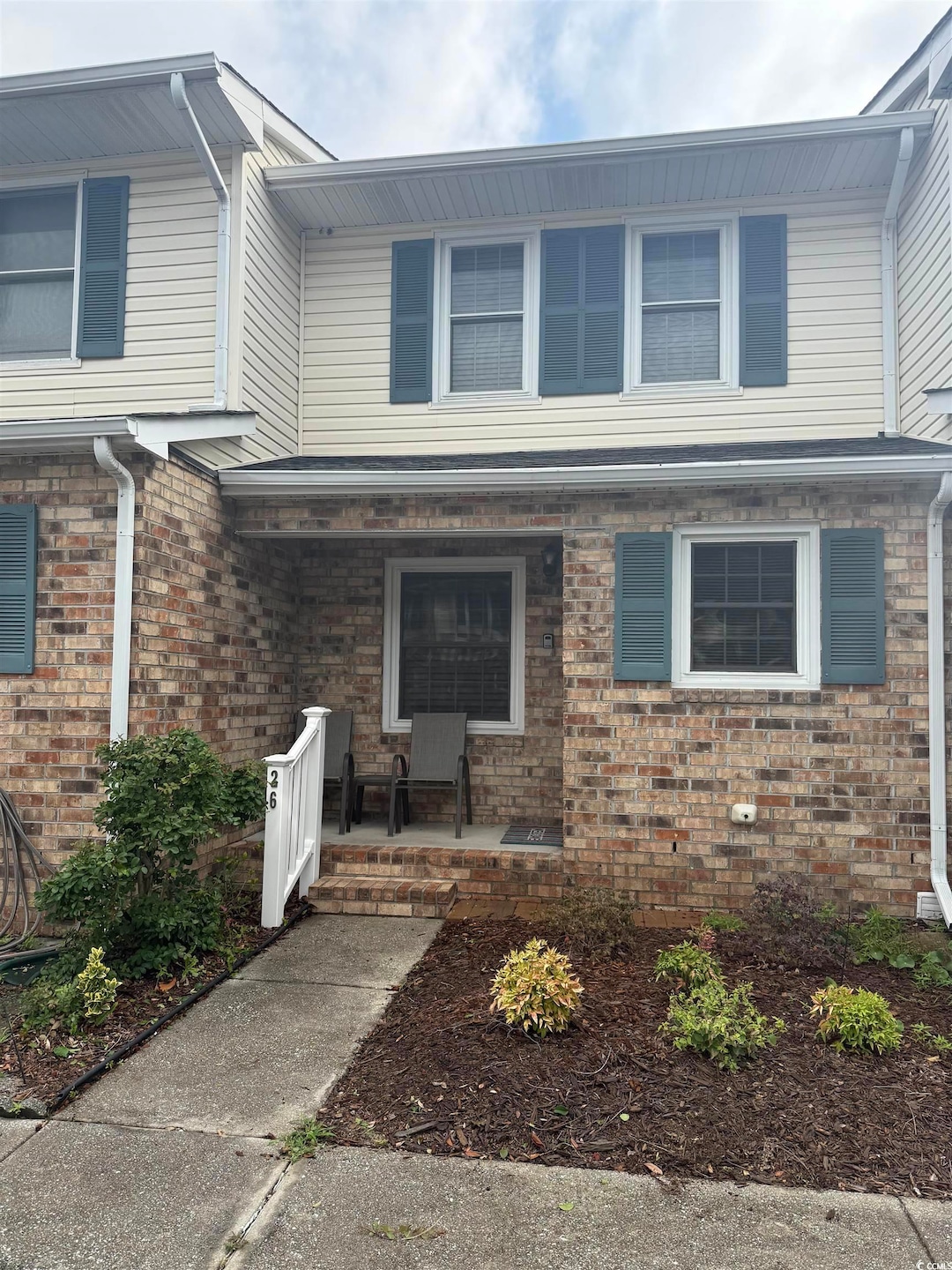 View of front facade with covered porch and brick siding