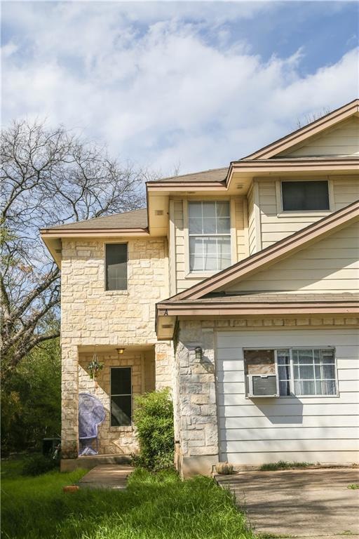 Back of property featuring stone siding