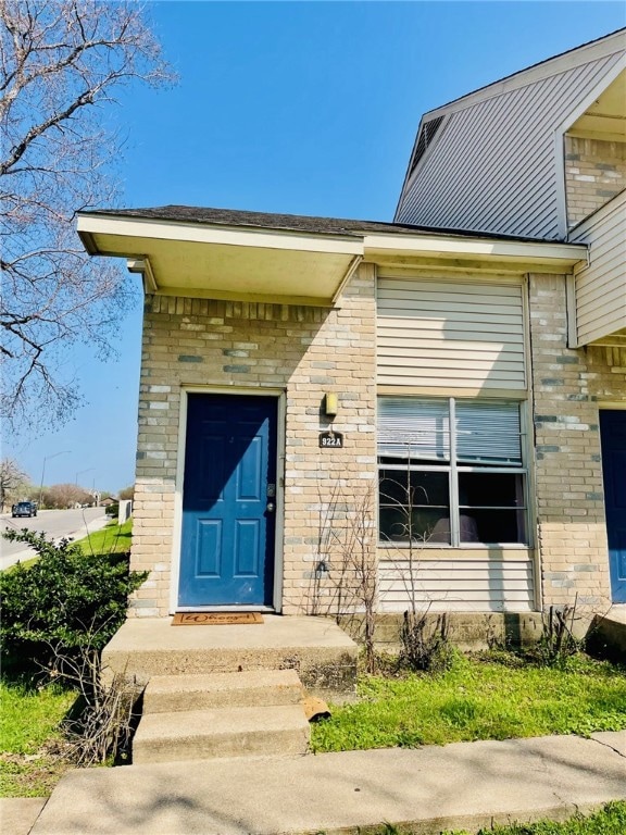 View of exterior entry with brick siding