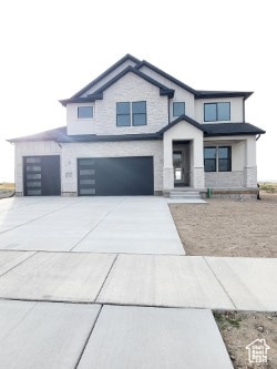 View of front facade with driveway and an attached garage