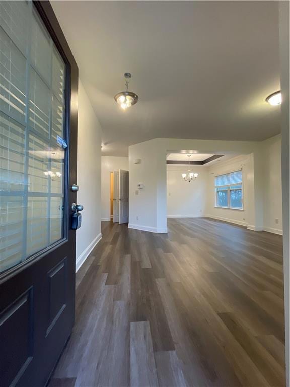 Entryway featuring baseboards, a notable chandelie
