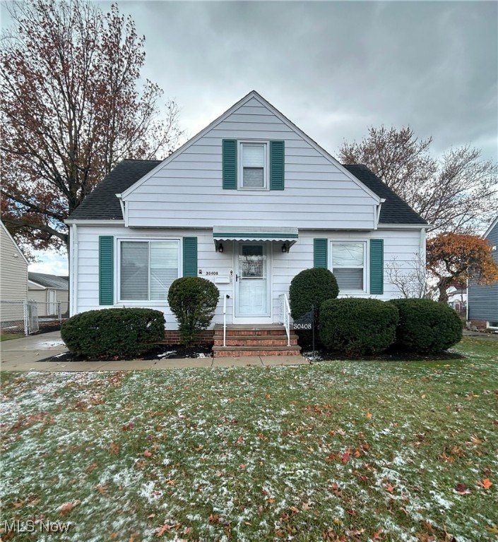 Bungalow with a front lawn and a shingled roof