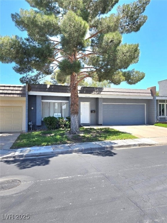 Ranch-style home with a garage, stucco siding, and