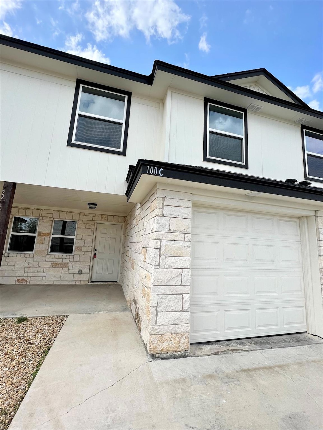 View of property with a garage and stone siding