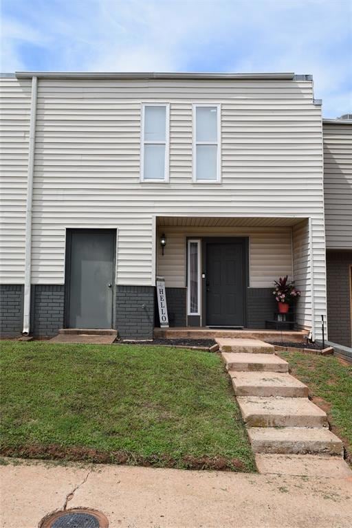 View of front of house with a front lawn and brick siding