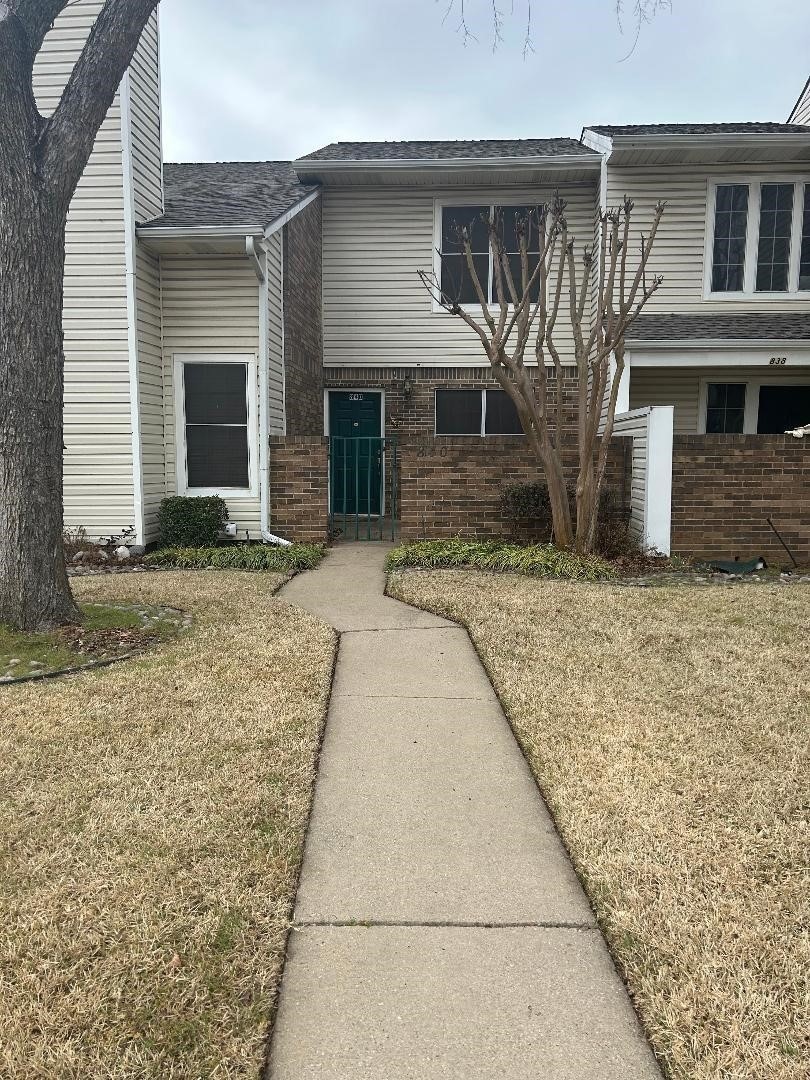 View of front of property with brick siding and a front lawn