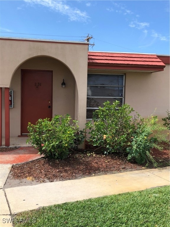 Property entrance with metal roof and stucco sidin