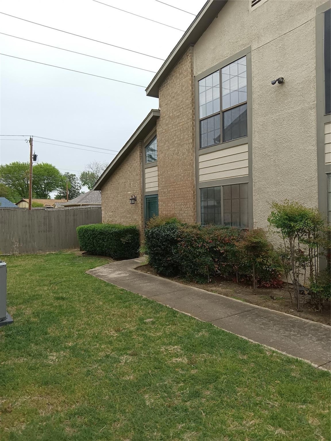 View of side of home featuring stucco siding, fenc