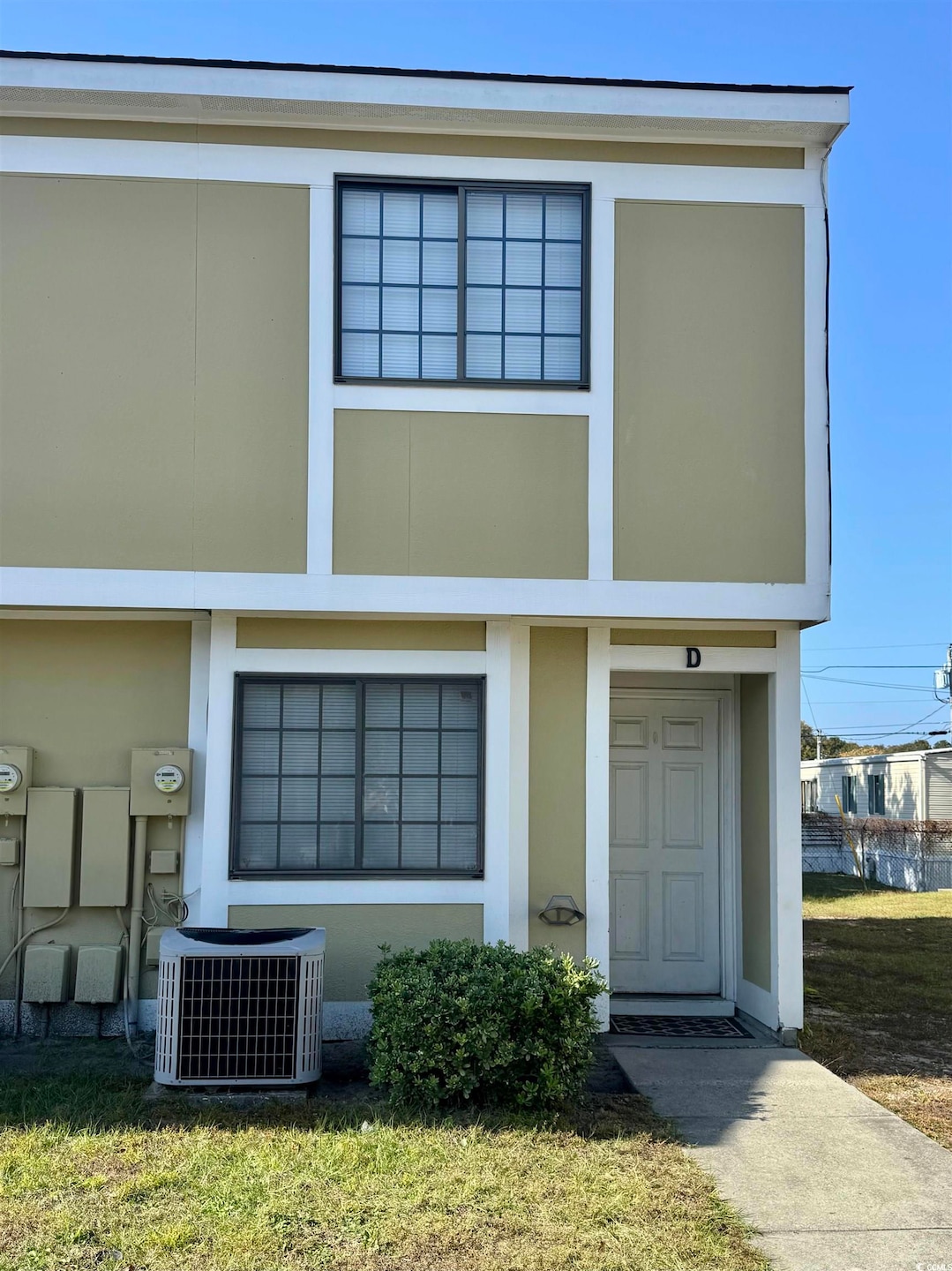 View of front facade featuring stucco siding and a front lawn