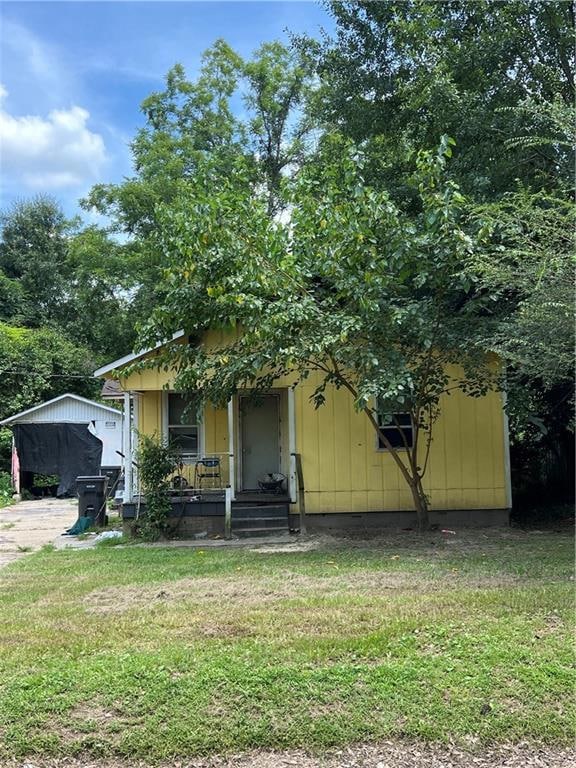 View of front of house featuring covered porch and a front lawn