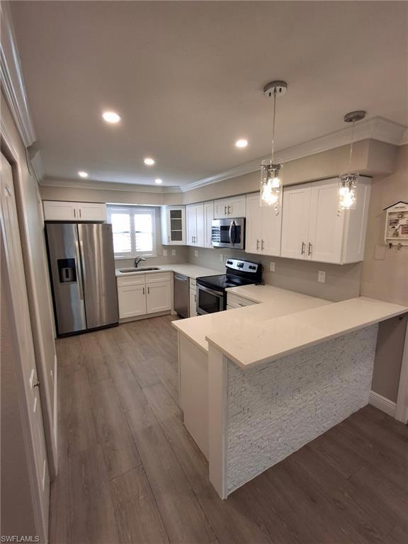 Kitchen featuring white cabinetry, decorative ligh