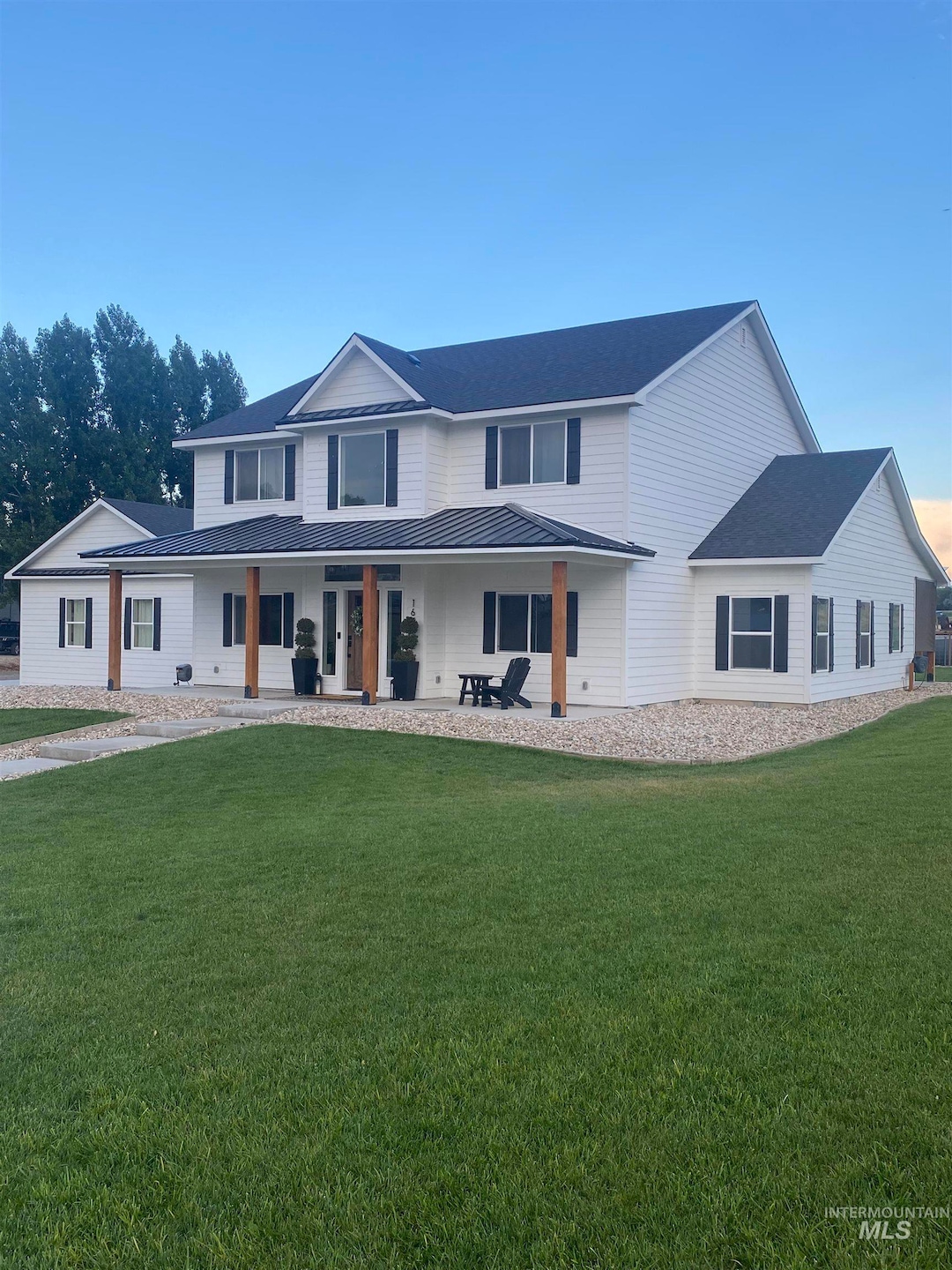 View of front facade featuring a front lawn and roof with shingles