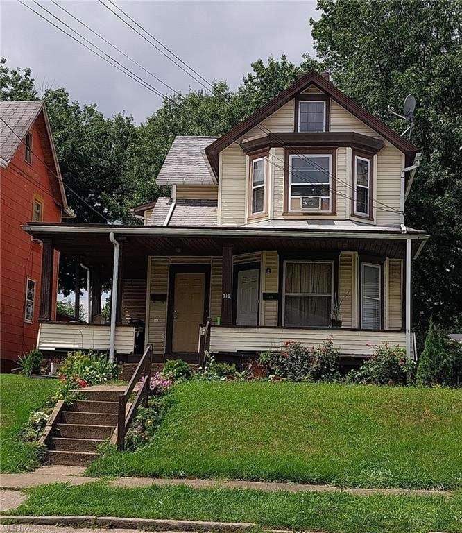 View of front facade with a porch and a front lawn