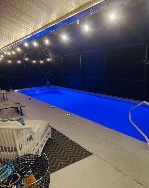 Pool at twilight with a lanai, an outdoor pool, an