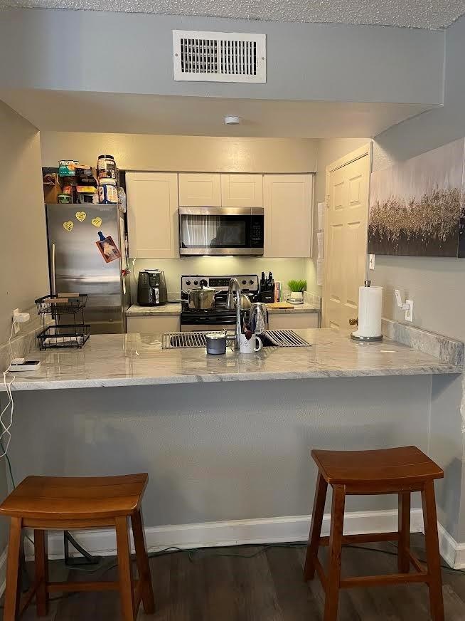 Kitchen with visible vents, light stone countertop