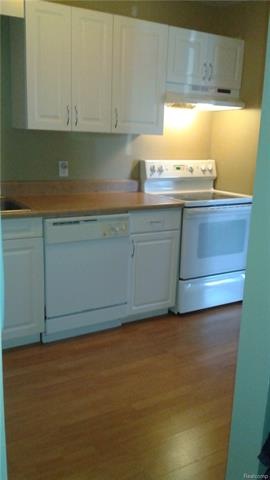 Updated kitchen with white cabinets and appliances