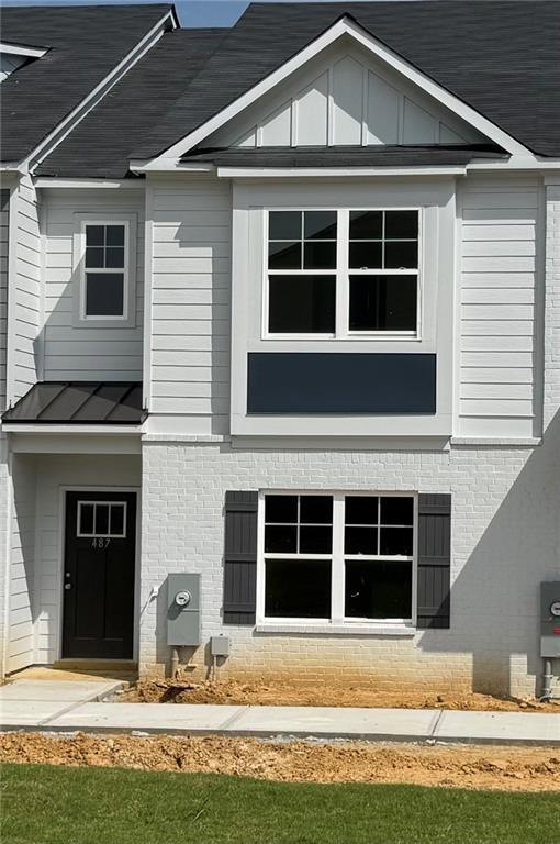Back of house featuring a standing seam roof, meta