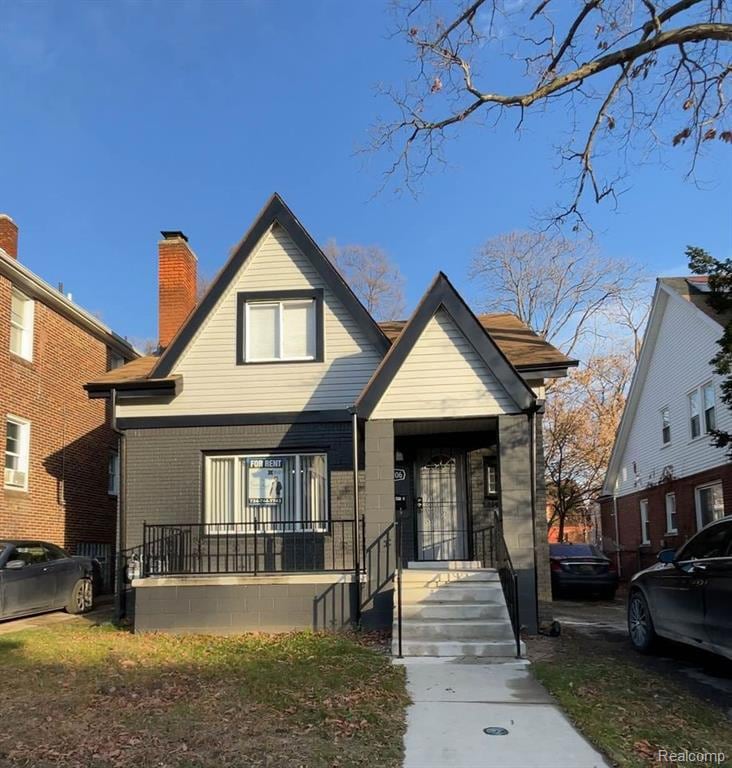 Bungalow-style house with brick siding and a chimney
