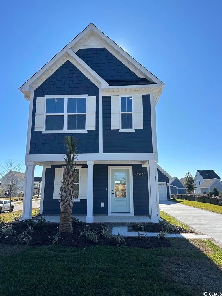 View of front of home featuring a porch, a front yard, and concrete driveway