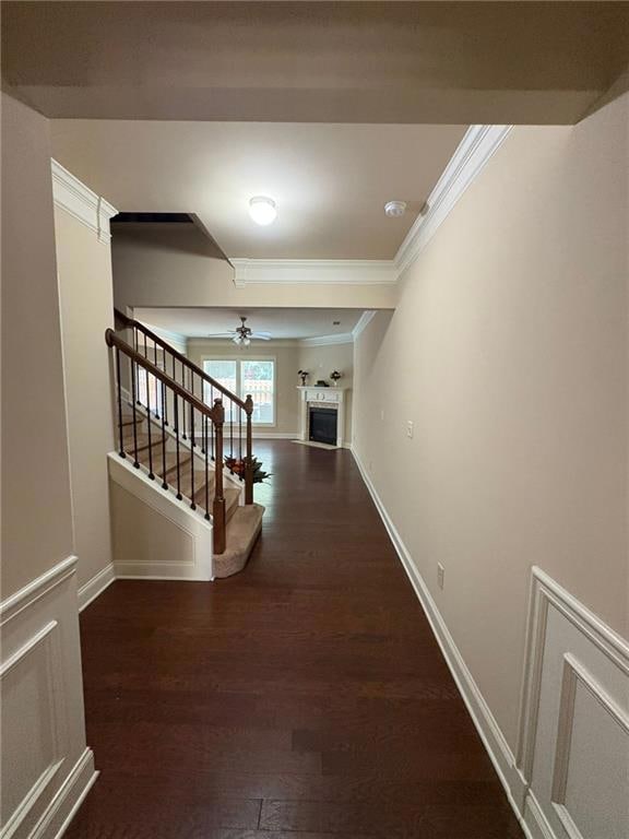 Corridor with crown molding, stairs, and wood finished floors