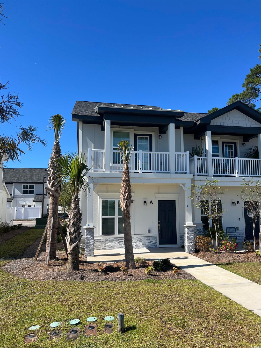 View of front of home featuring stucco siding, a front yard, and roof with shingles