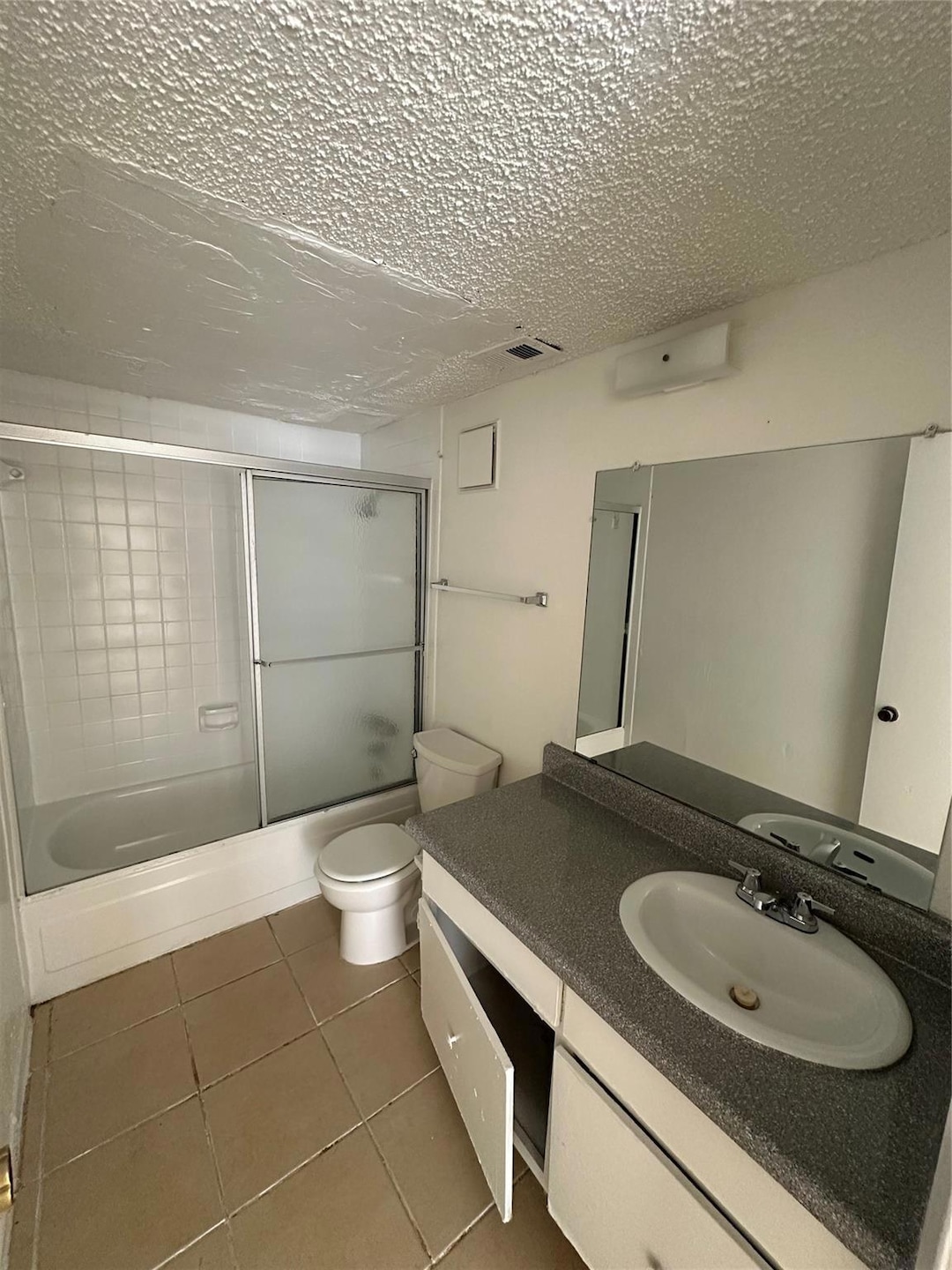 Bathroom with vanity, enclosed tub / shower combo,