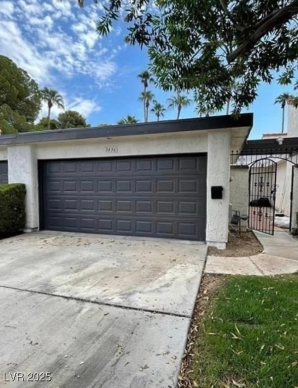 Garage with driveway and a gated entryway to front