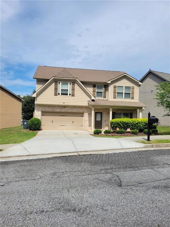 View of front of house with concrete driveway, brick siding, and a garage