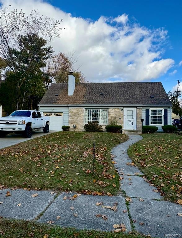 View of front of home with a garage, concrete driveway, a front lawn, a chimney, and a shingled roof