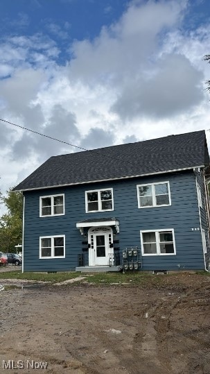 Colonial house featuring roof with shingles