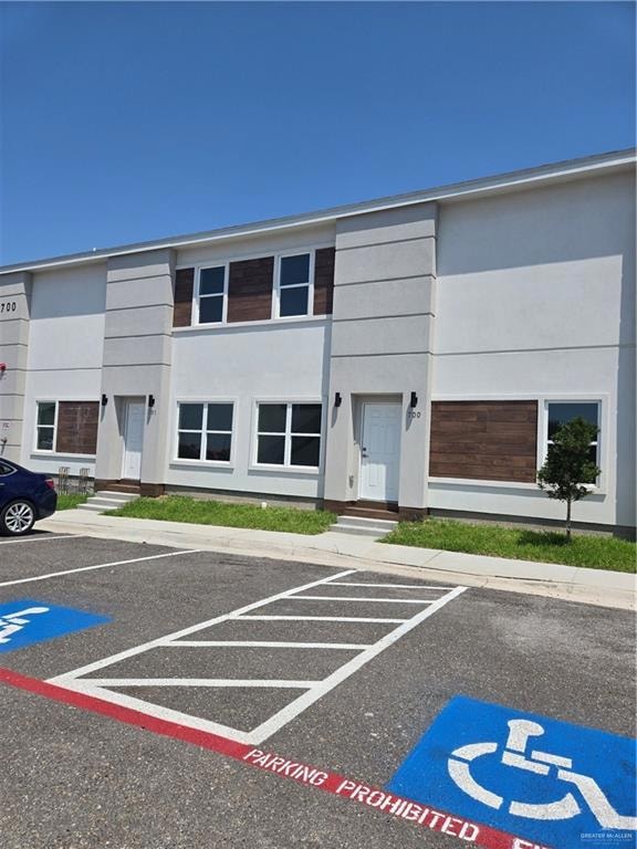 View of property with uncovered parking