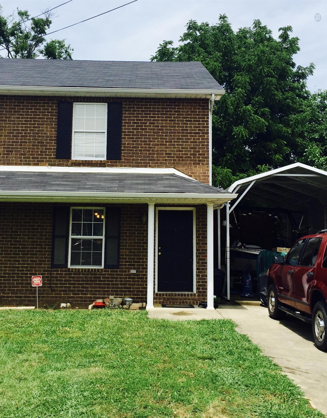 Brick front exterior with carport.