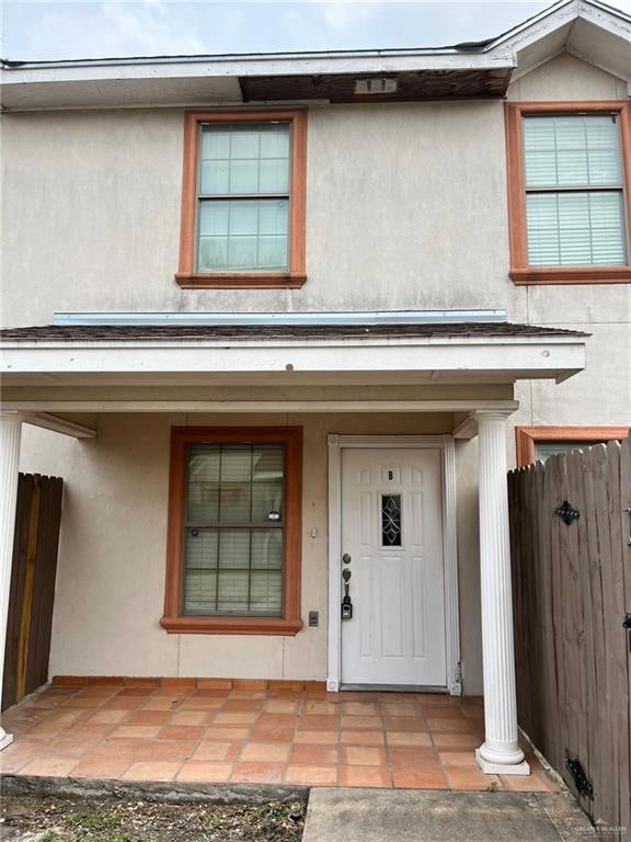 Entrance to property featuring stucco siding and covered porch