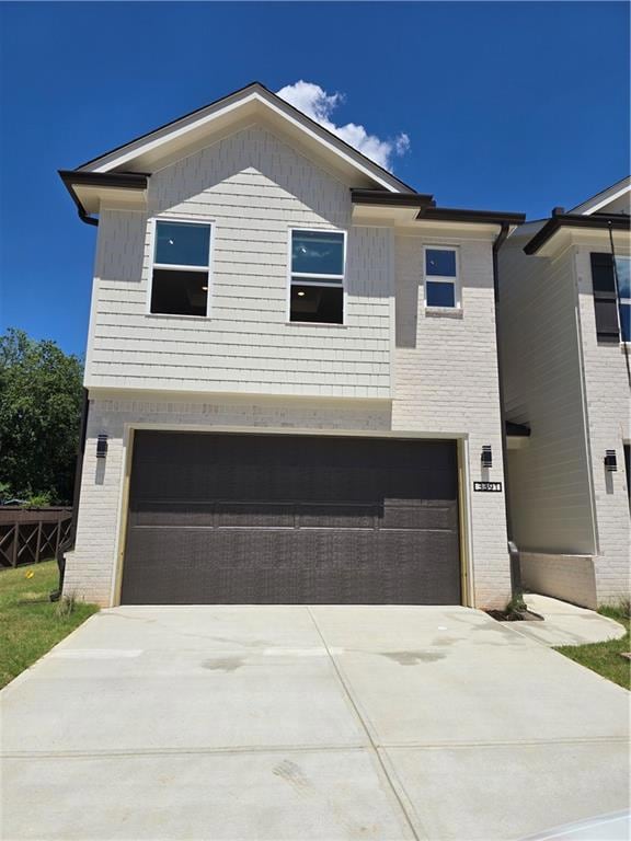 View of front facade with concrete driveway, a garage, and brick siding