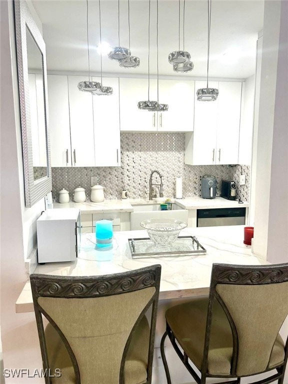 Kitchen with white cabinetry, backsplash, a breakf