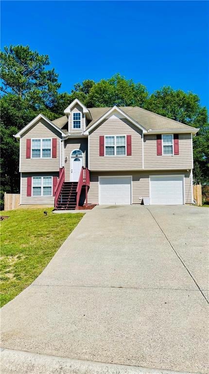 Split foyer home featuring an attached garage, driveway, and a front lawn