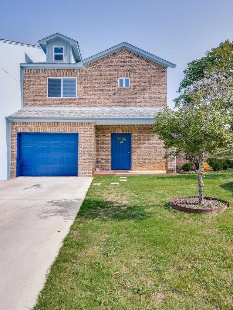 View of front facade with a garage and a front law